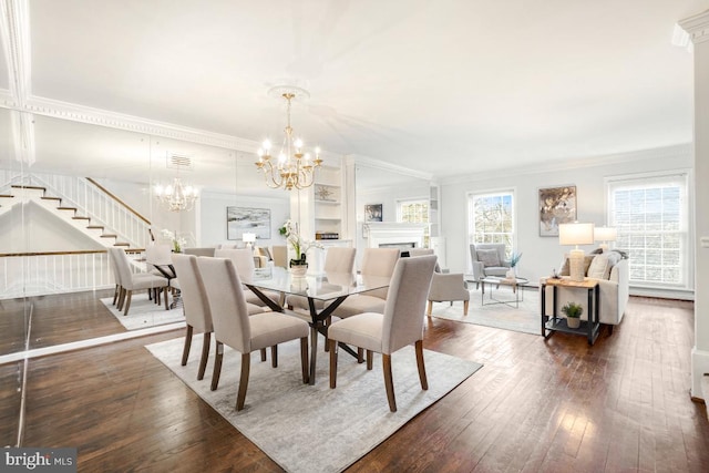 dining space featuring dark hardwood / wood-style flooring, crown molding, and a chandelier