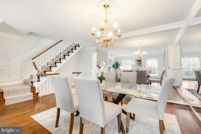 dining space with crown molding, a chandelier, and hardwood / wood-style floors