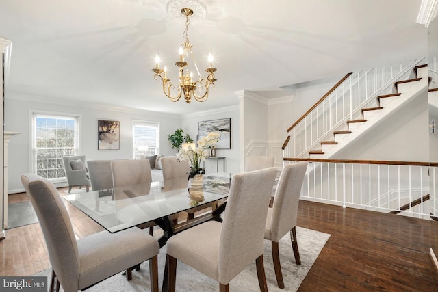 dining room with a notable chandelier, crown molding, and wood-type flooring