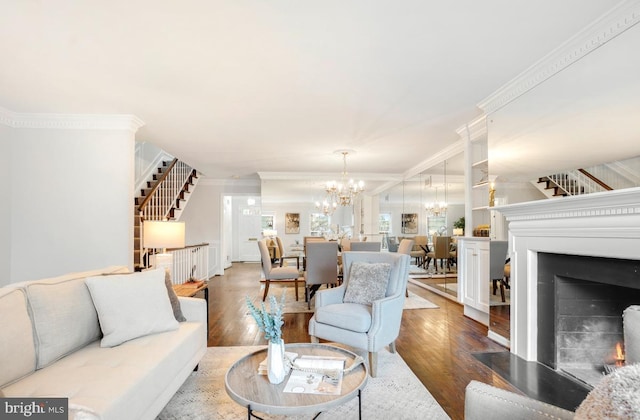 living room featuring crown molding, wood-type flooring, and a notable chandelier