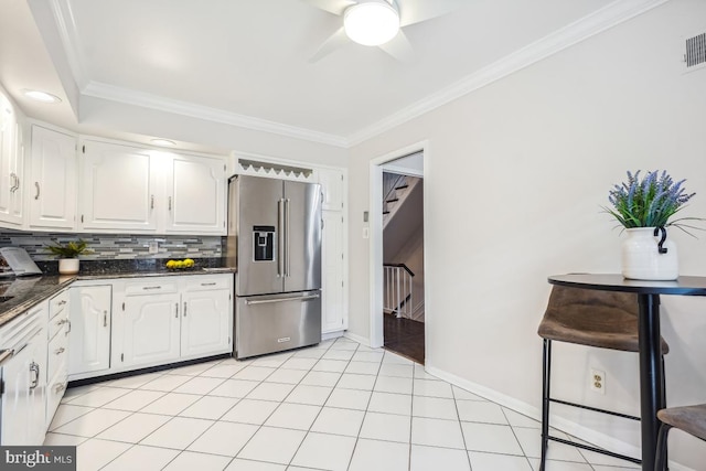 kitchen with white cabinetry, backsplash, dark stone countertops, ornamental molding, and high end refrigerator