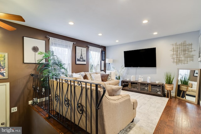 living room featuring dark wood-type flooring and ceiling fan