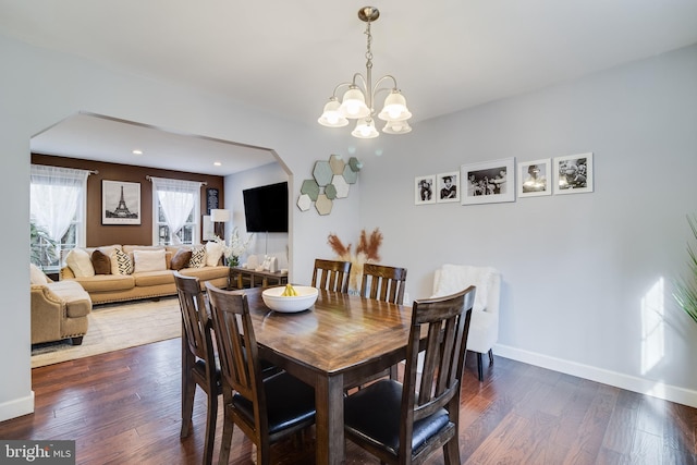 dining space with an inviting chandelier and dark hardwood / wood-style flooring