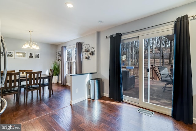 dining area featuring dark hardwood / wood-style flooring and a chandelier