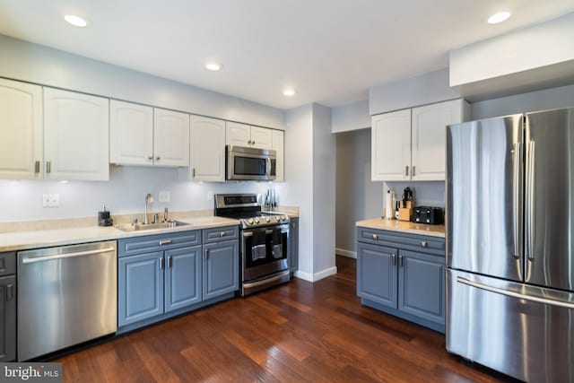 kitchen with blue cabinets, sink, dark hardwood / wood-style floors, stainless steel appliances, and white cabinets