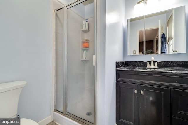 bathroom with toilet, vanity, and walk in shower