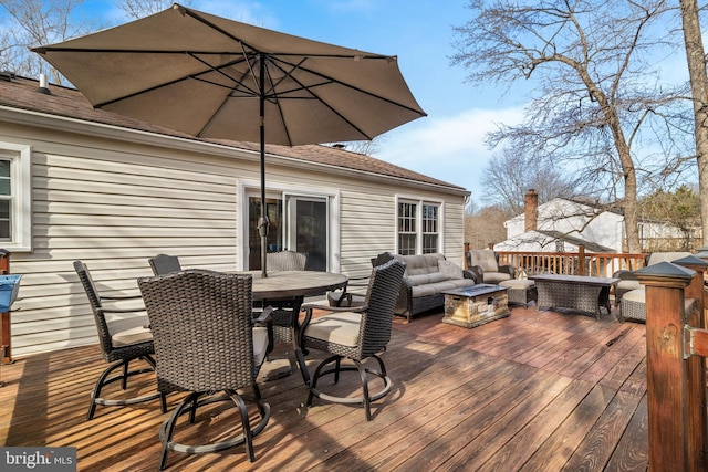 deck with an outdoor living space with a fire pit