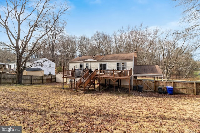 back of house with a deck and a storage unit