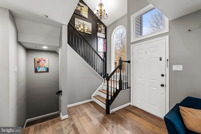 foyer with a notable chandelier and wood-type flooring