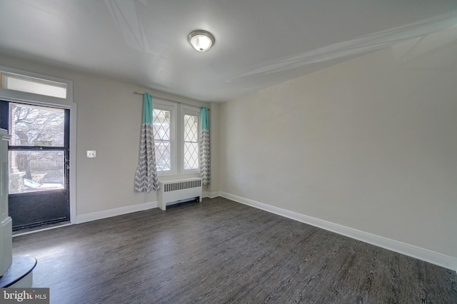 empty room with radiator and dark hardwood / wood-style floors