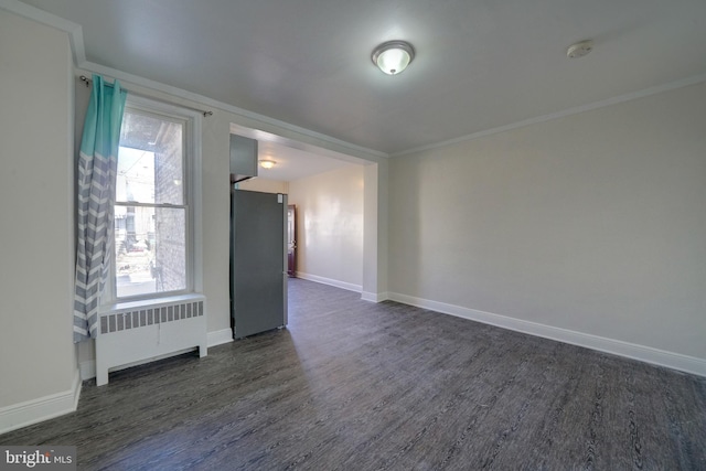 unfurnished room with crown molding, radiator heating unit, and dark hardwood / wood-style flooring