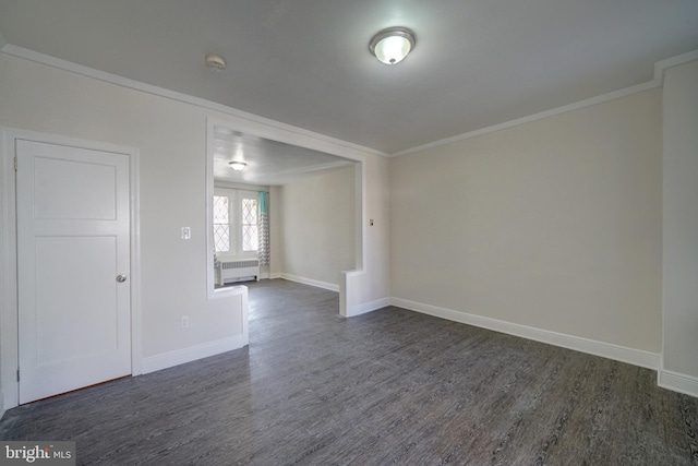 unfurnished room featuring crown molding, radiator heating unit, and dark hardwood / wood-style flooring