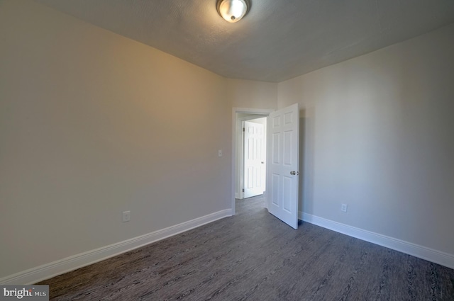 spare room with dark wood-type flooring and a textured ceiling