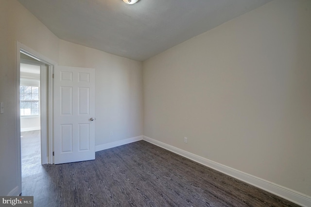 unfurnished room with lofted ceiling and dark wood-type flooring