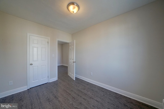 unfurnished room with dark hardwood / wood-style flooring