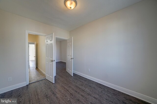 unfurnished bedroom featuring dark hardwood / wood-style flooring