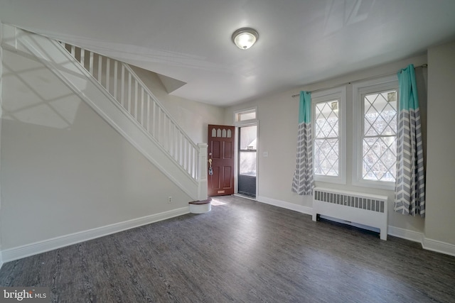 entrance foyer with radiator heating unit and dark hardwood / wood-style flooring