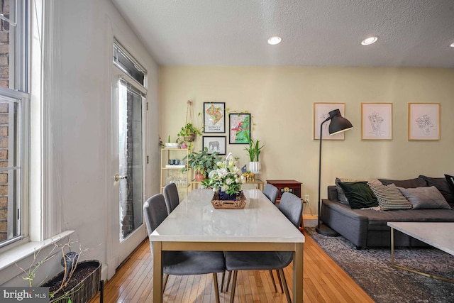 dining space featuring light hardwood / wood-style floors and a textured ceiling