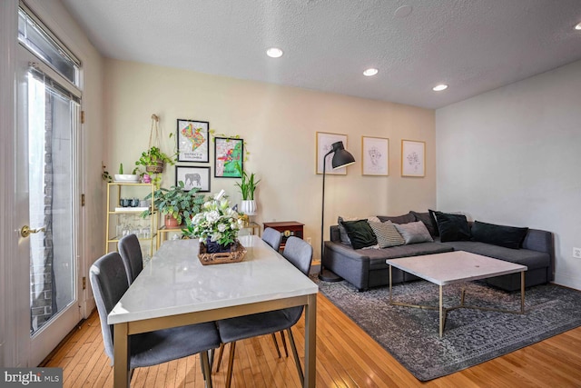 dining room with light hardwood / wood-style flooring and a textured ceiling