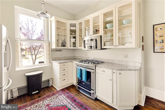 kitchen with dark hardwood / wood-style flooring, white cabinets, and appliances with stainless steel finishes