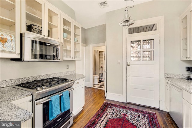 kitchen featuring stainless steel appliances, dark wood-type flooring, white cabinets, and light stone counters