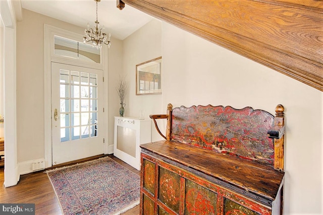 entryway with an inviting chandelier and dark hardwood / wood-style flooring