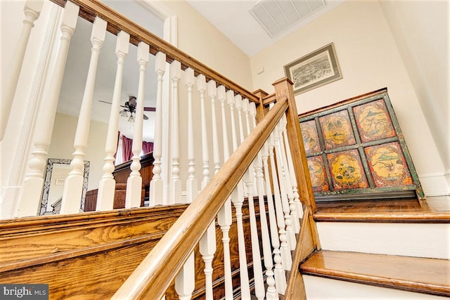 stairway featuring ceiling fan