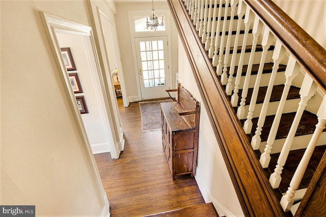 stairs with a notable chandelier and hardwood / wood-style flooring