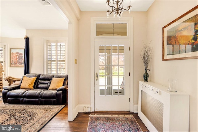 doorway to outside featuring dark hardwood / wood-style floors and a notable chandelier