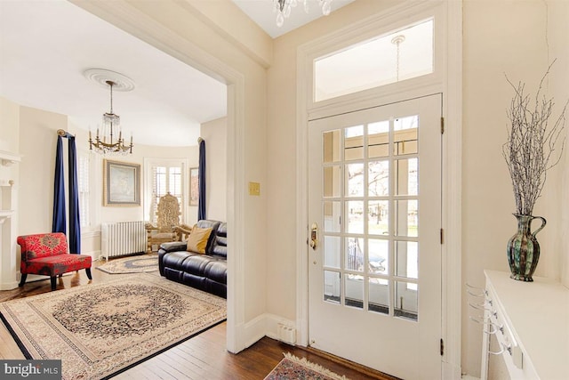 entryway featuring radiator heating unit, dark hardwood / wood-style floors, and a notable chandelier