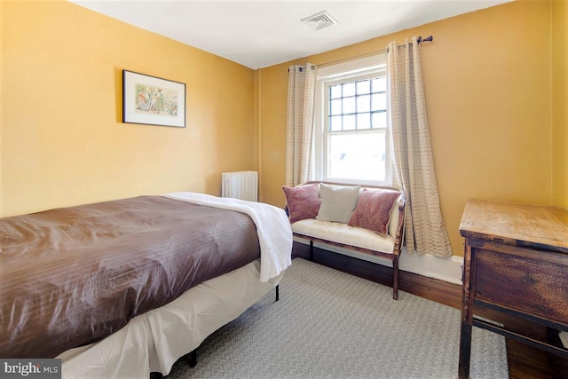 bedroom with hardwood / wood-style flooring and radiator heating unit