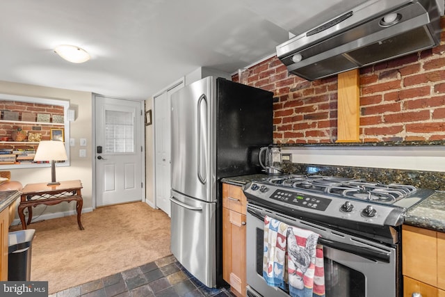 kitchen with dark colored carpet, stainless steel appliances, extractor fan, and dark stone countertops