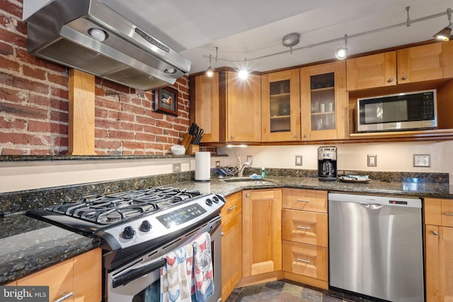 kitchen with pendant lighting, stainless steel appliances, extractor fan, and dark stone counters