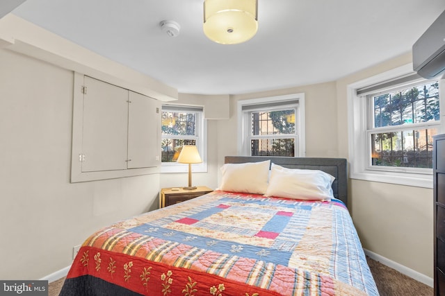 carpeted bedroom with a wall mounted air conditioner and multiple windows