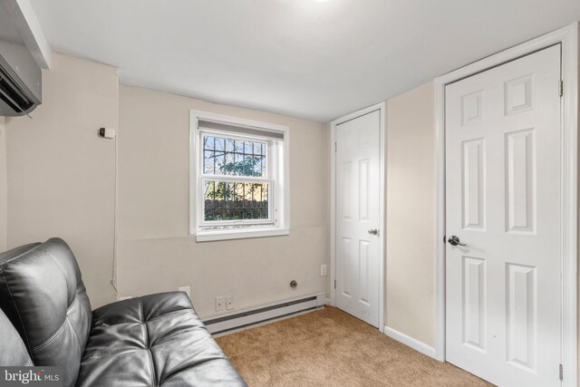 living area with light carpet, a baseboard heating unit, and a wall mounted air conditioner