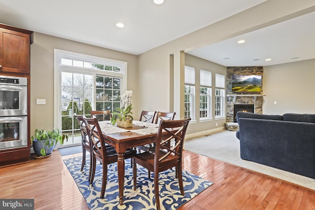 dining area featuring a fireplace and light hardwood / wood-style floors