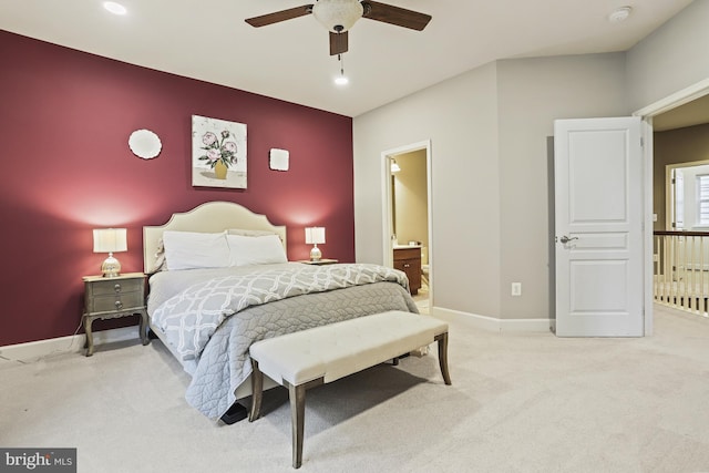 bedroom with ceiling fan, light carpet, and ensuite bath