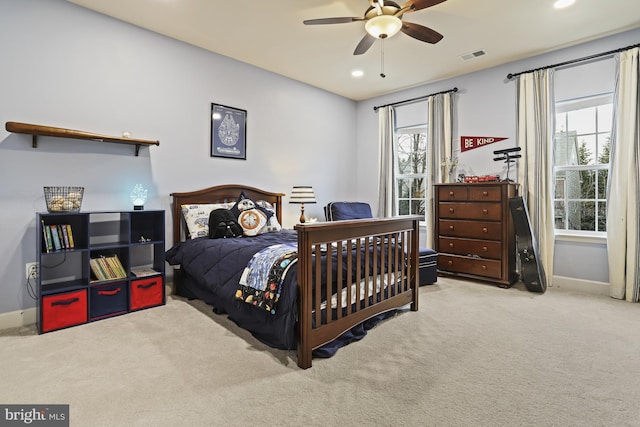 carpeted bedroom with multiple windows and ceiling fan