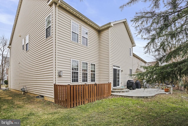 rear view of house with a patio area and a lawn