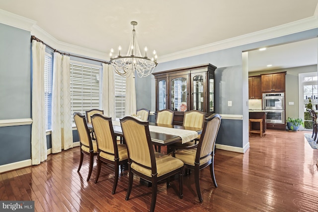 dining space featuring dark hardwood / wood-style flooring, crown molding, and a chandelier