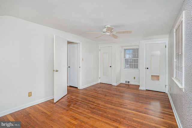 unfurnished bedroom with ceiling fan and dark hardwood / wood-style flooring