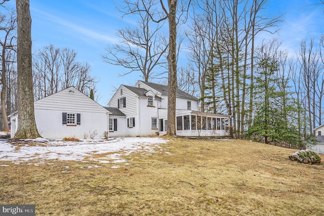 snow covered property featuring a lawn and a sunroom