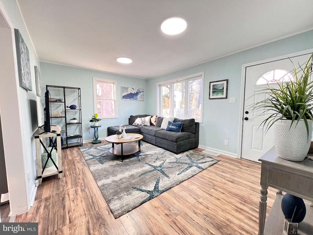 living room featuring wood-type flooring and ornamental molding