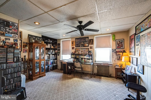 home office with radiator, a paneled ceiling, ceiling fan, and carpet flooring