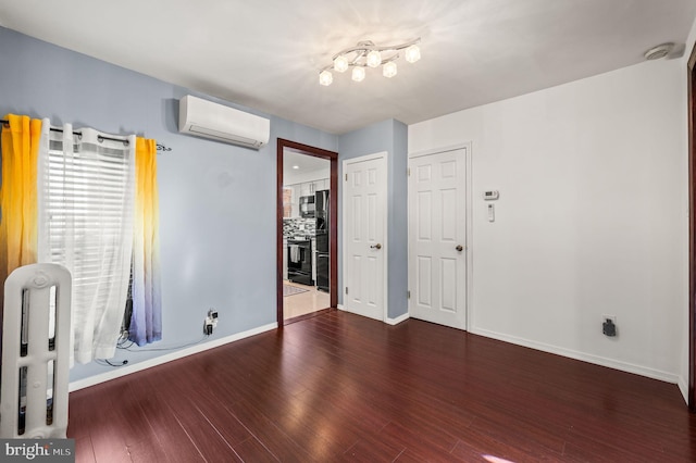 empty room with dark hardwood / wood-style flooring and an AC wall unit