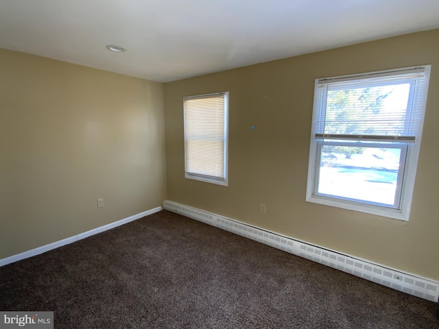 carpeted spare room with a baseboard radiator