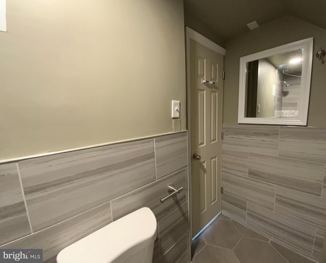 bathroom with tile walls and tile patterned flooring