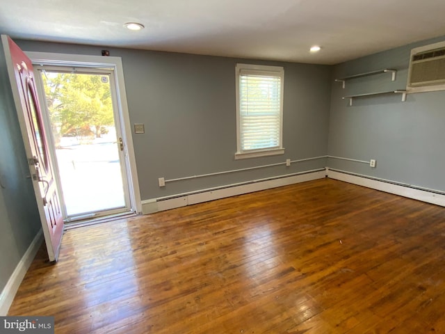 interior space featuring a wall mounted air conditioner and hardwood / wood-style flooring