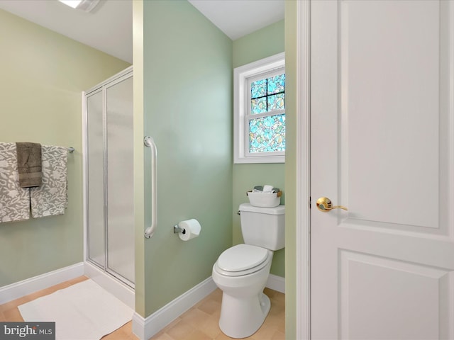 bathroom with a shower with door, tile patterned flooring, and toilet