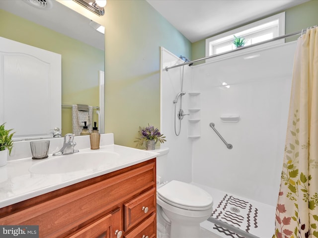 bathroom featuring a shower with curtain, vanity, and toilet